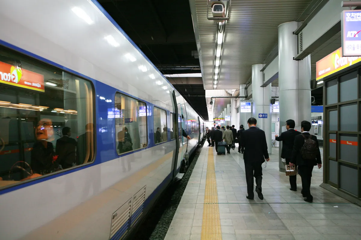 Tàu KTX cạnh sân ga có mái che với hành khách