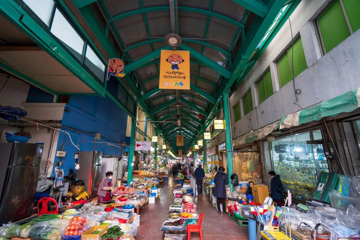 Quầy nông sản dưới lối có mái ở chợ Gangneung Jungang