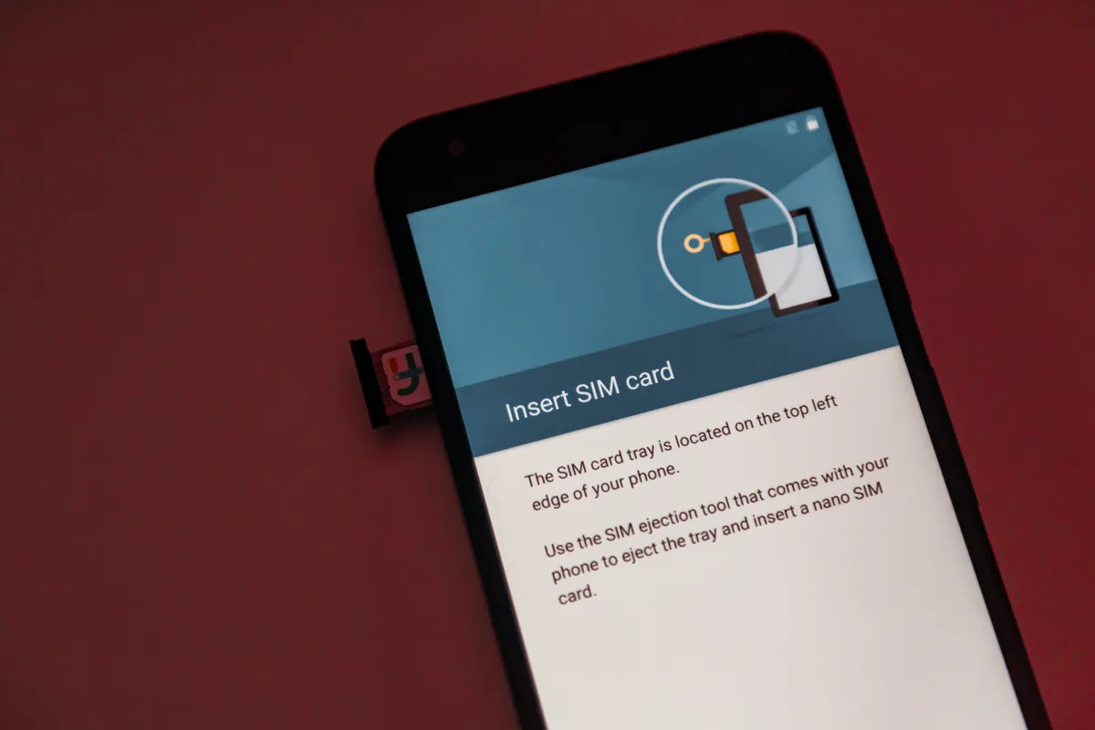 SIM physique dans le tiroir partiellement sorti d’un LG Nexus 5X, à côté de l’écran du téléphone