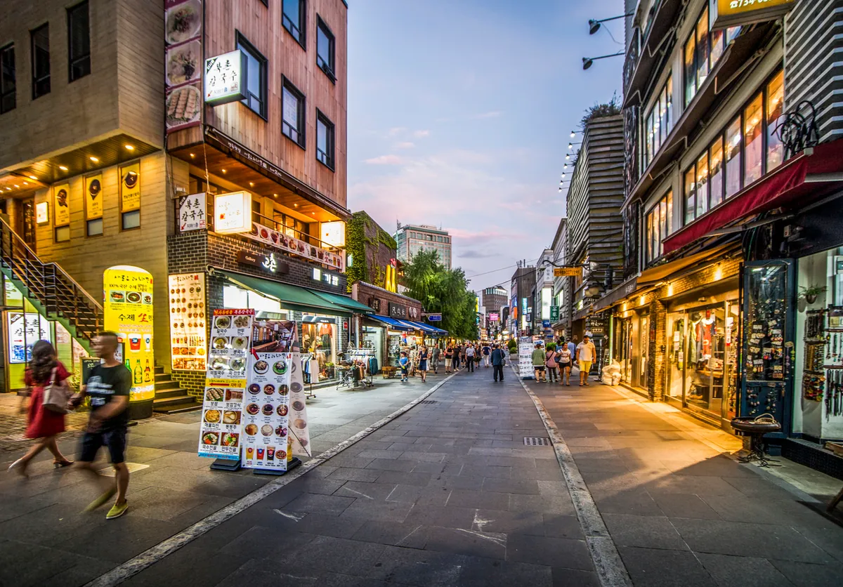 Beleuchtete Geschäfte und Restaurants an einer Straße in Insadong bei Dämmerung