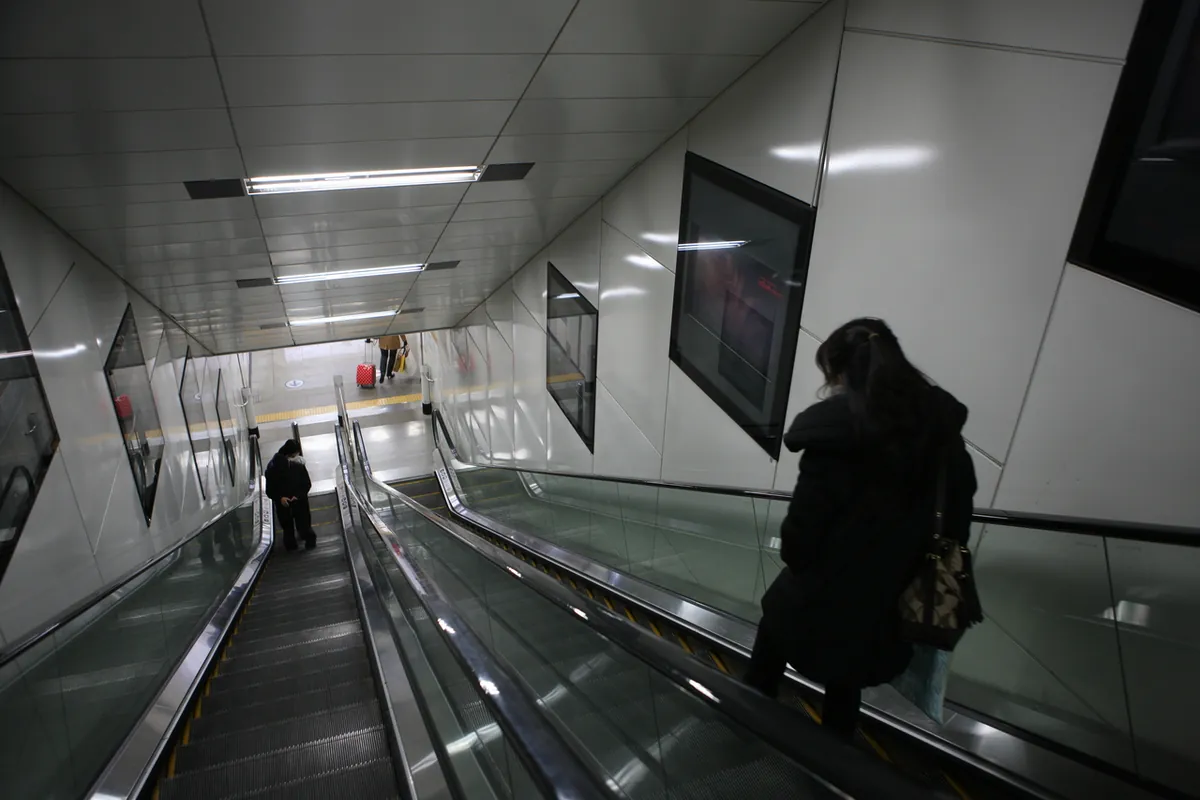 Longs escalators reliant les niveaux d'une station de métro de Séoul