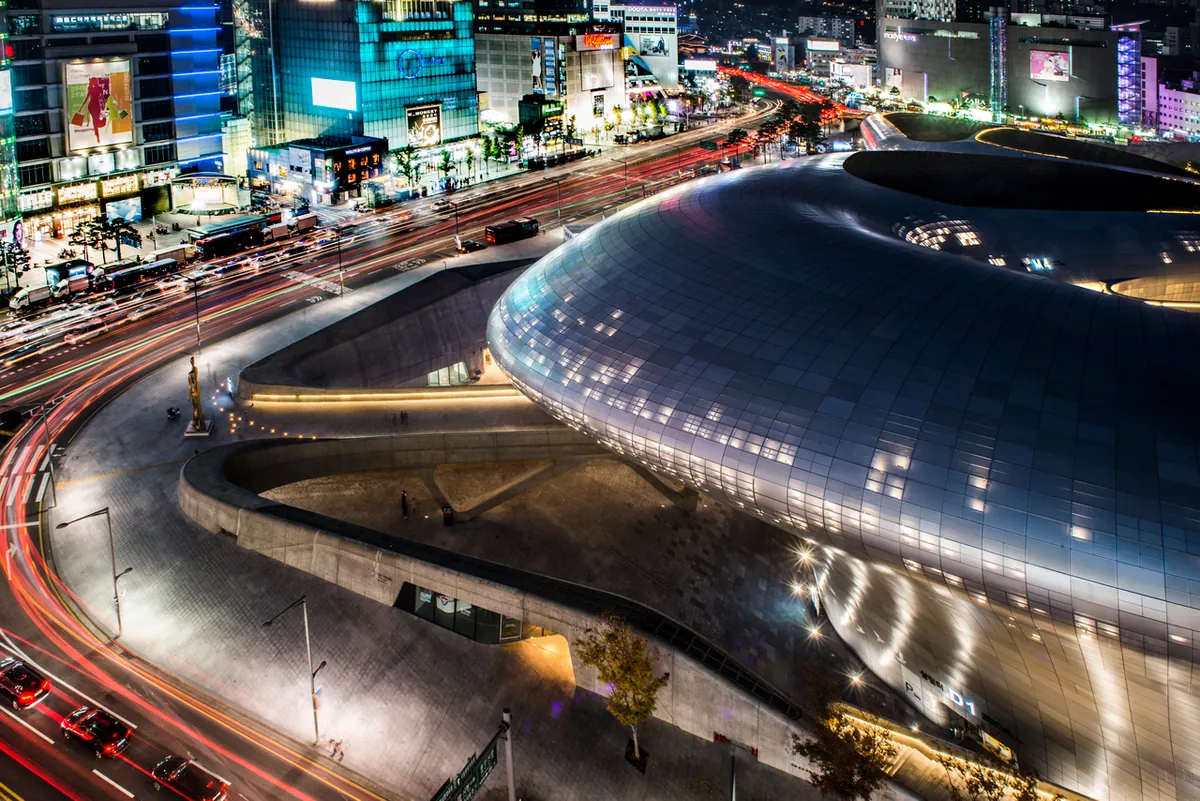 Dongdaemun Design Plaza illuminated beside city roads at night