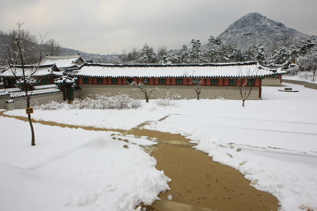 Tuyết phủ sân Gyeongbokgung cạnh đường đã dọn và nhà mái ngói