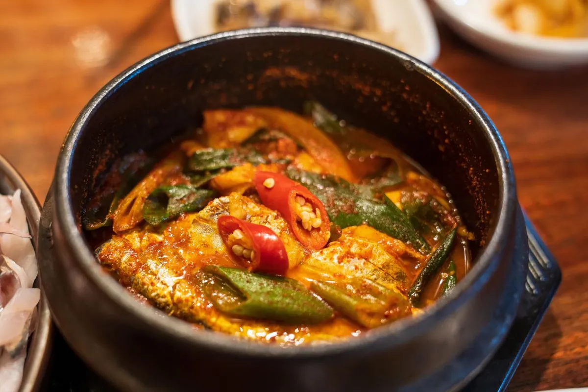 Ikan layur Jeju dimasak pedas bersama sayuran dalam panci hitam