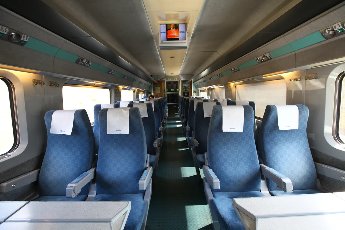 Ghế hành khách xanh và bàn bên trong toa KTX