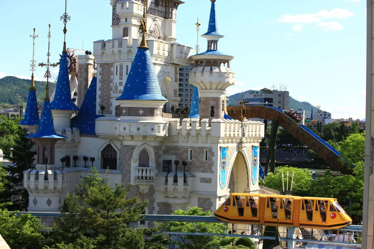 The Magic Island castle and yellow monorail beside the lake
