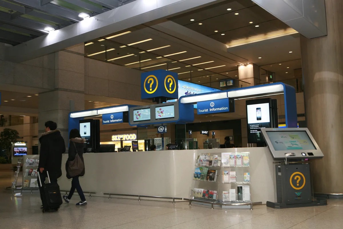 仁川国際空港内の観光案内所の前を歩く旅行者