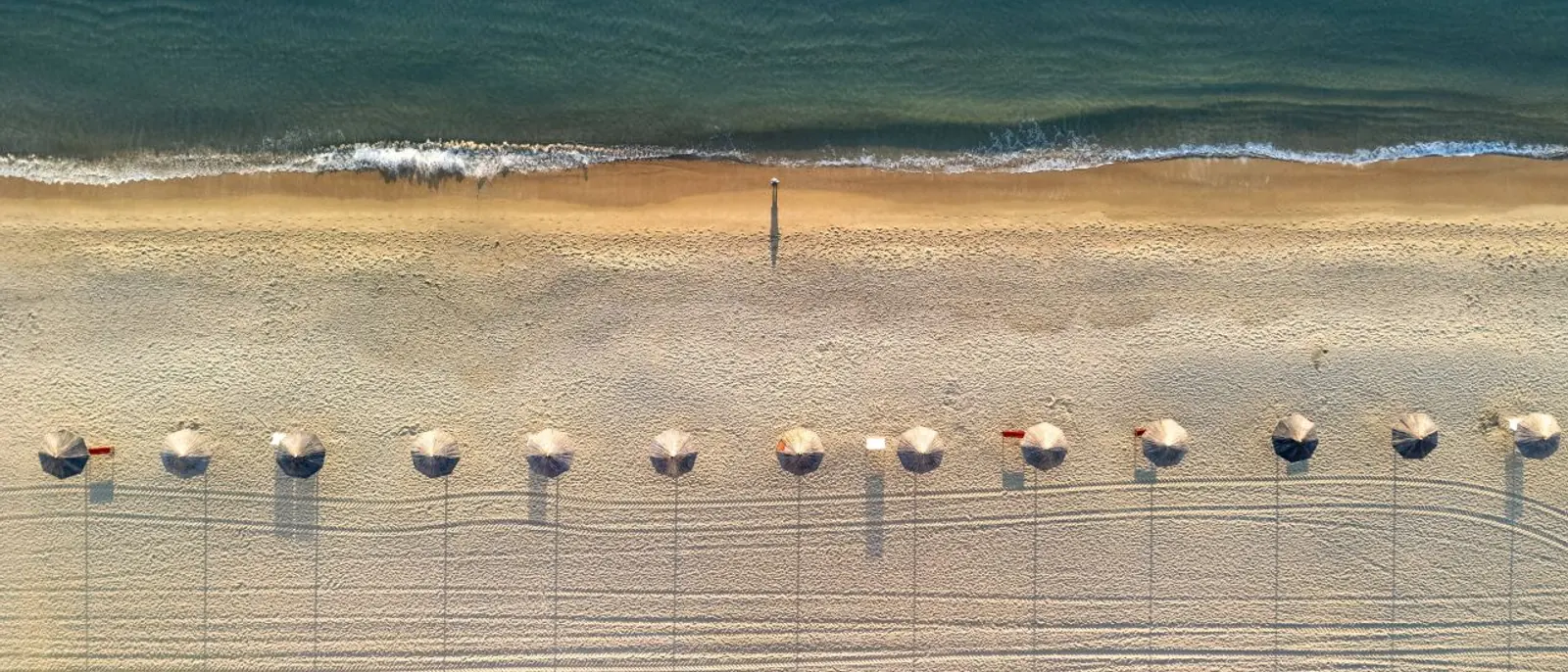 Quiet winter shoreline and parasols at Gwangalli Beach in Busan