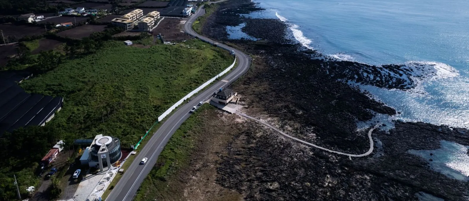 A coastal road following Jeju's black-rock eastern shoreline